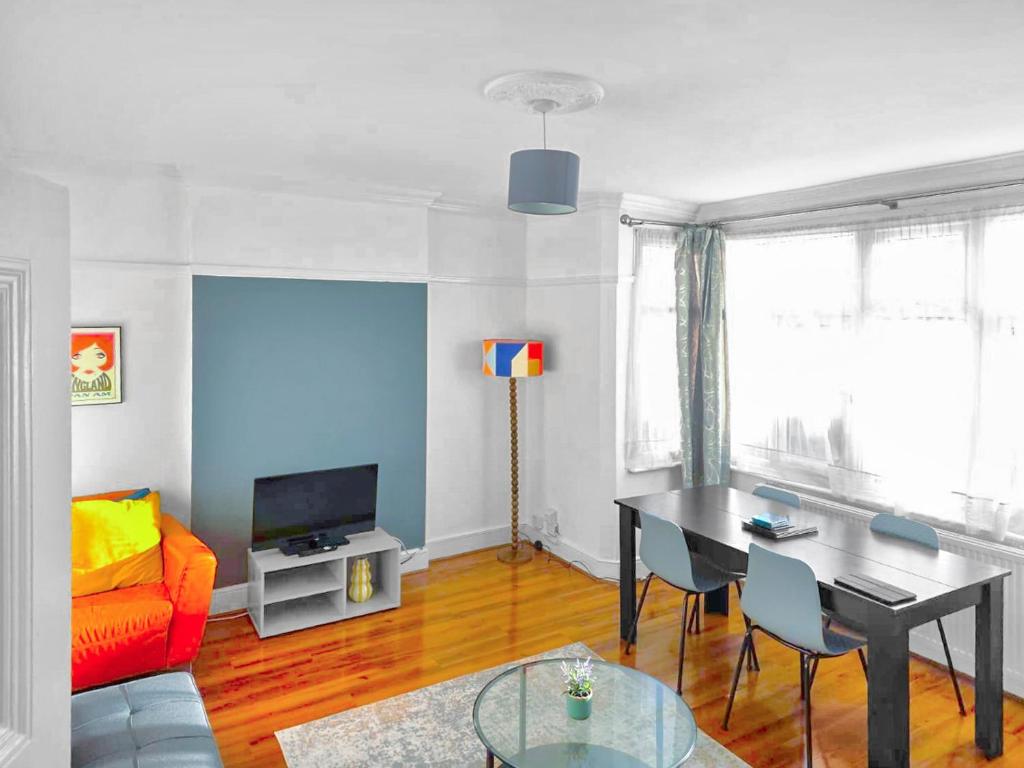 a living room with a table and a couch at 3-Bed Duplex Flat, Free WIFI & Great Transport Links in Norwood