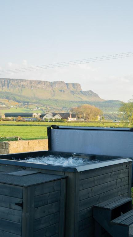 a barbecue grill with a view of a field and mountains at Magilligan Lodge in Bellarena Station