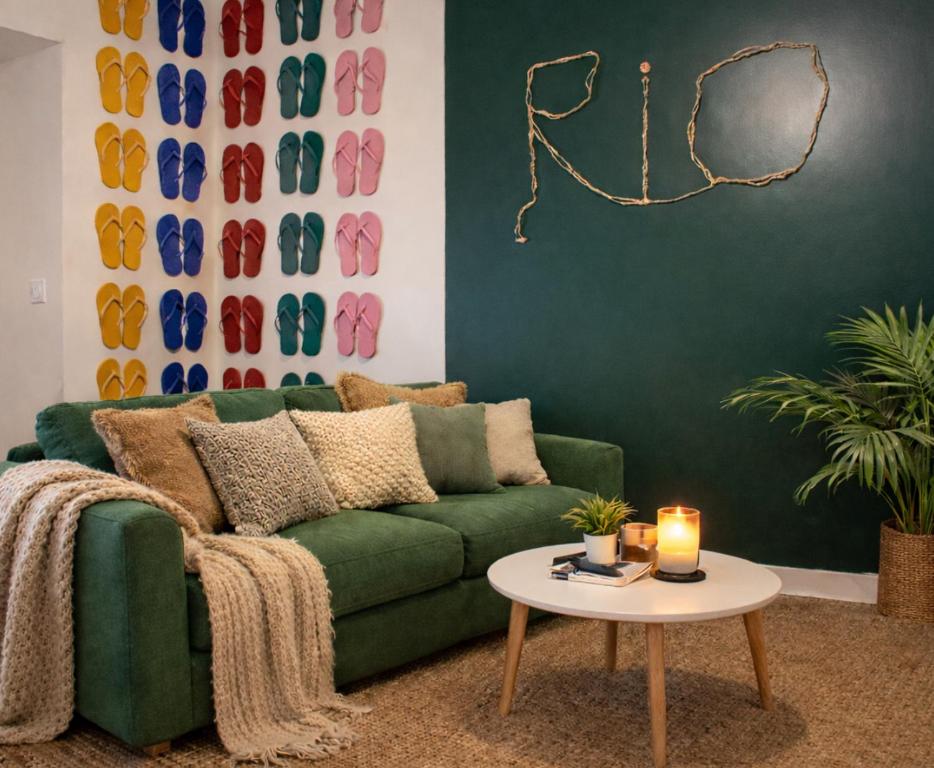 a living room with a green couch and a table at La casa Rio de Janeiro - parking & confort in Trignac