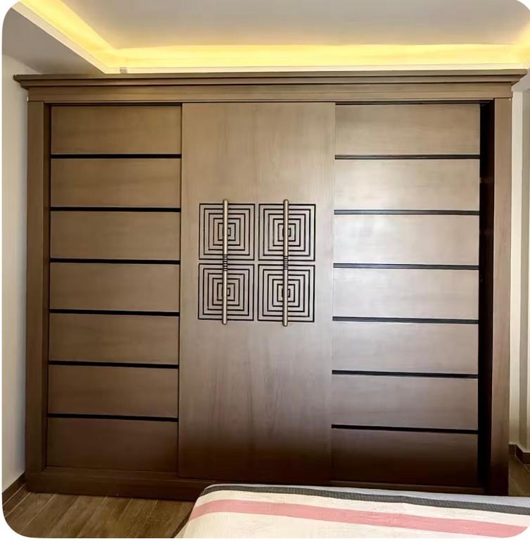 a closet with a wooden door with a design on it at شقة فندقيه بمدينتي in Madinaty