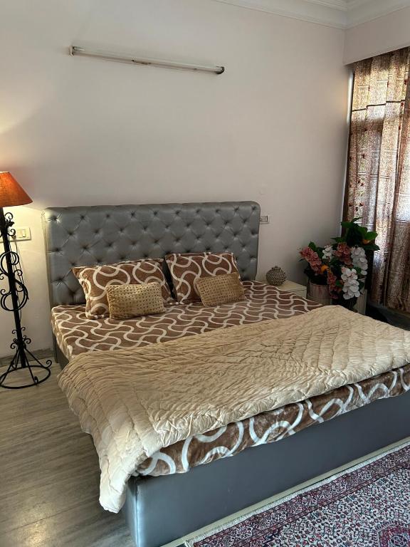 a bedroom with a large bed with a metal headboard at Happy Homes 2BHK Second Floor Panchkula in Panchkula