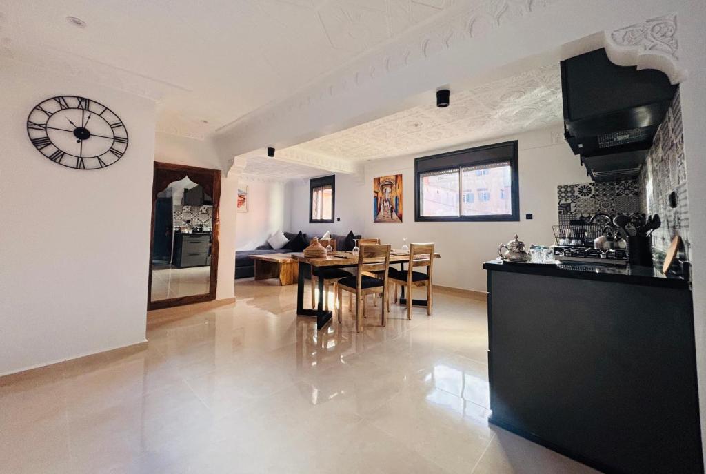 a kitchen and dining room with a clock on the wall at Inass appartement in Essaouira