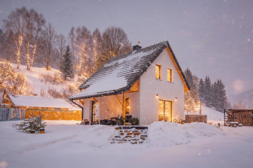 a small white house with snow on the roof at Luisówka - majestatyczny domek z jacuzzi in Stronie Śląskie