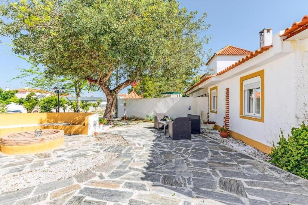 a patio with a tree and a house at O Mundo da Lua in Azeitao