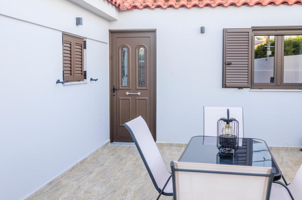 a dining room with a table and chairs and a door at Voidοkilia rooms in Petrochori