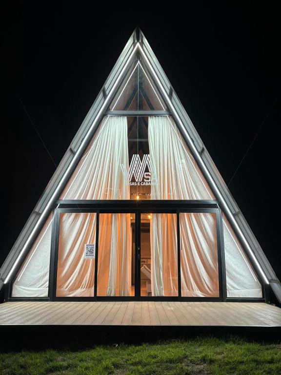 a triangleangular building with a window with curtains at Cabana WSA Piratuba SC in Piratuba