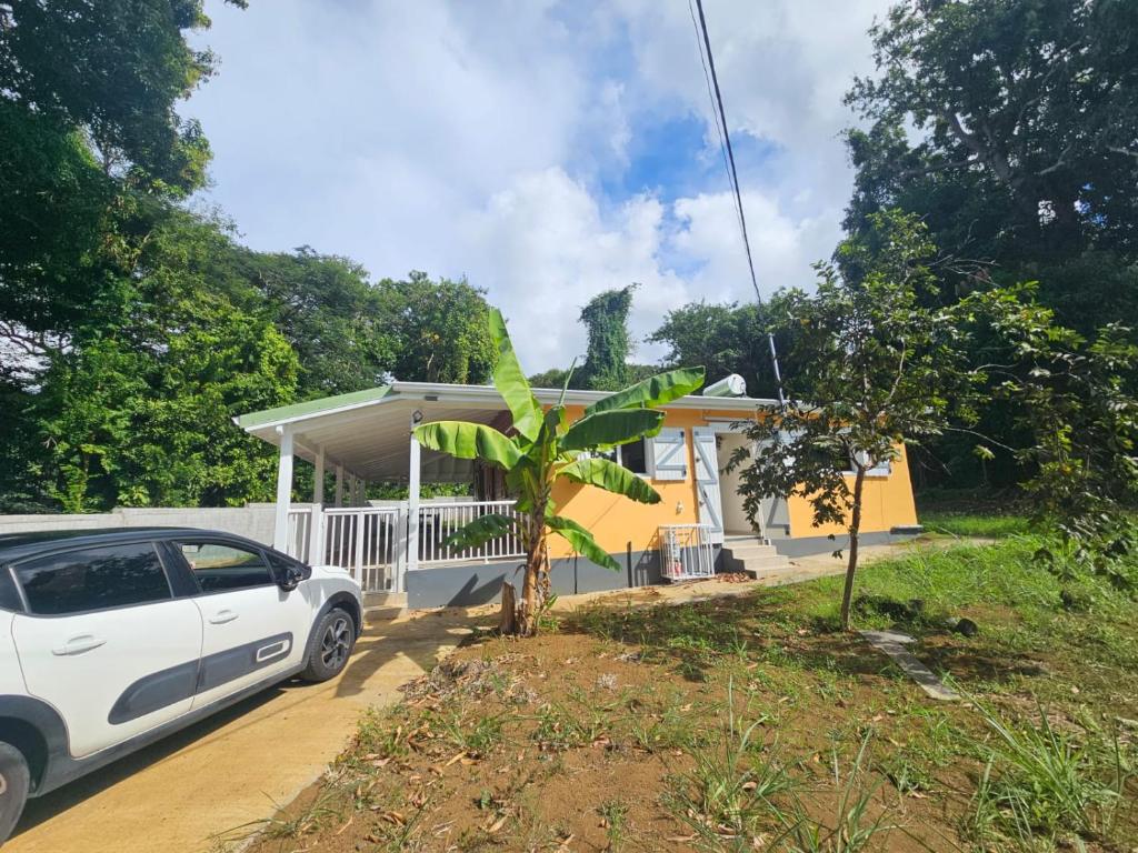a white car parked in front of a house at Maison de vacances in Deshaies