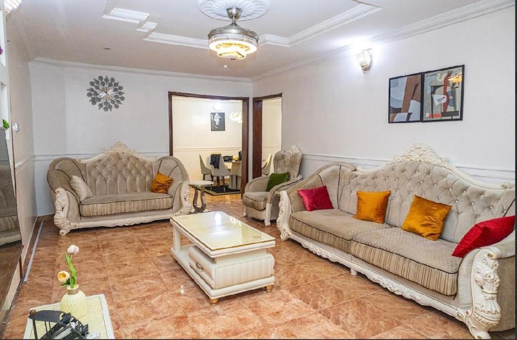 a living room with two couches and a table at 4 Kays Apartment in Agege