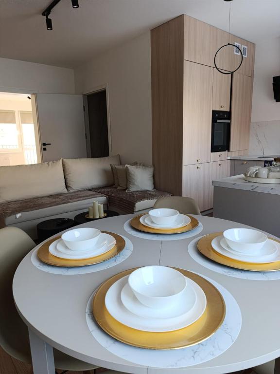a table with four plates on it in a living room at Apartament Kaszmir 3 in Sławno