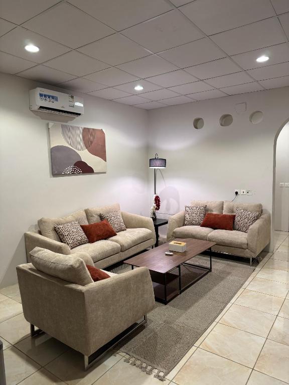 a living room with two couches and a coffee table at شقق أريز ستاي in Al Hada
