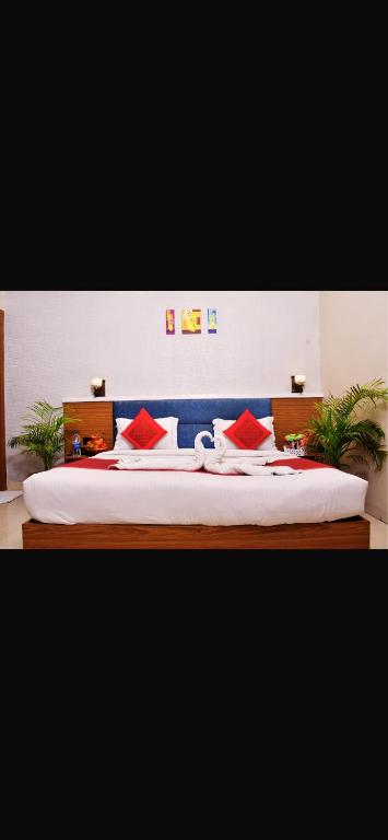 a bedroom with a large bed with red pillows at RamaLand A complete Stay in Faizābād
