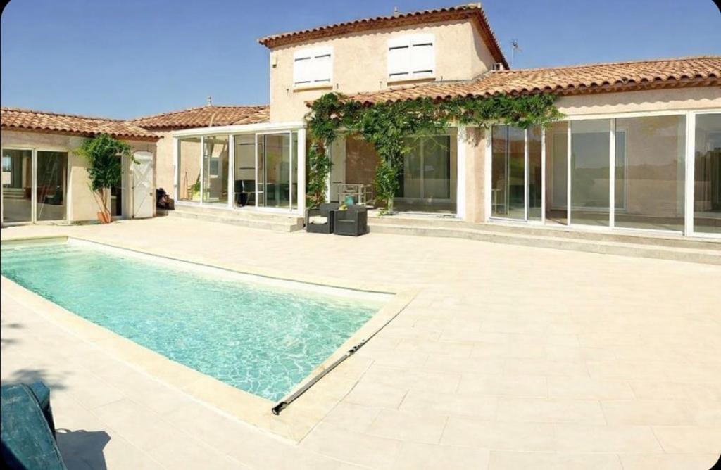 a house with a swimming pool in front of a house at Le Clos des Galets in Meynes