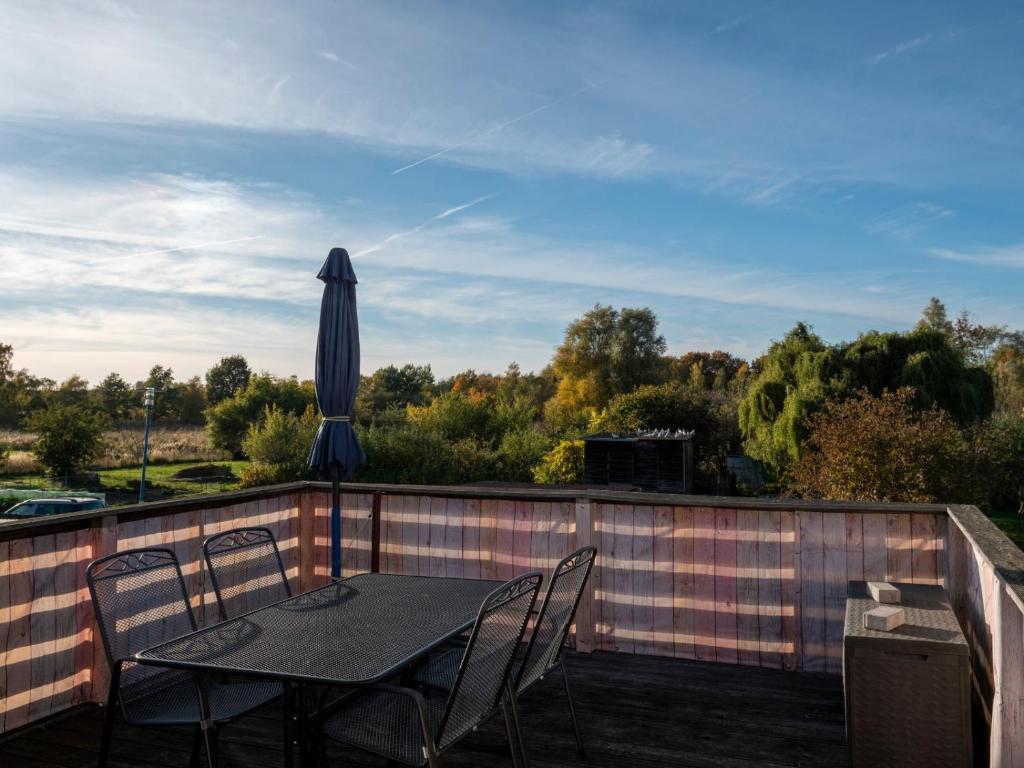 a table and chairs on a balcony with an umbrella at Ferienwohnung Wieck Greifswald in Wieck
