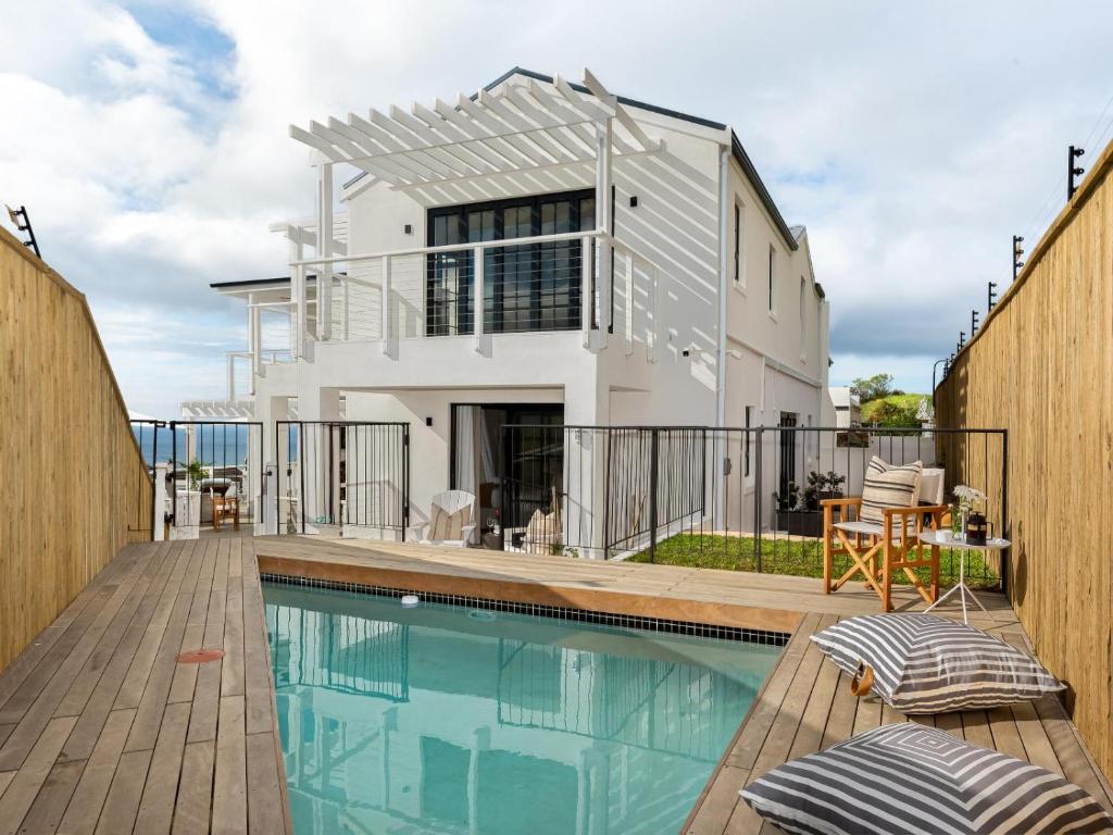 a home with a swimming pool and a house at Arc Guest House in Simonʼs Town
