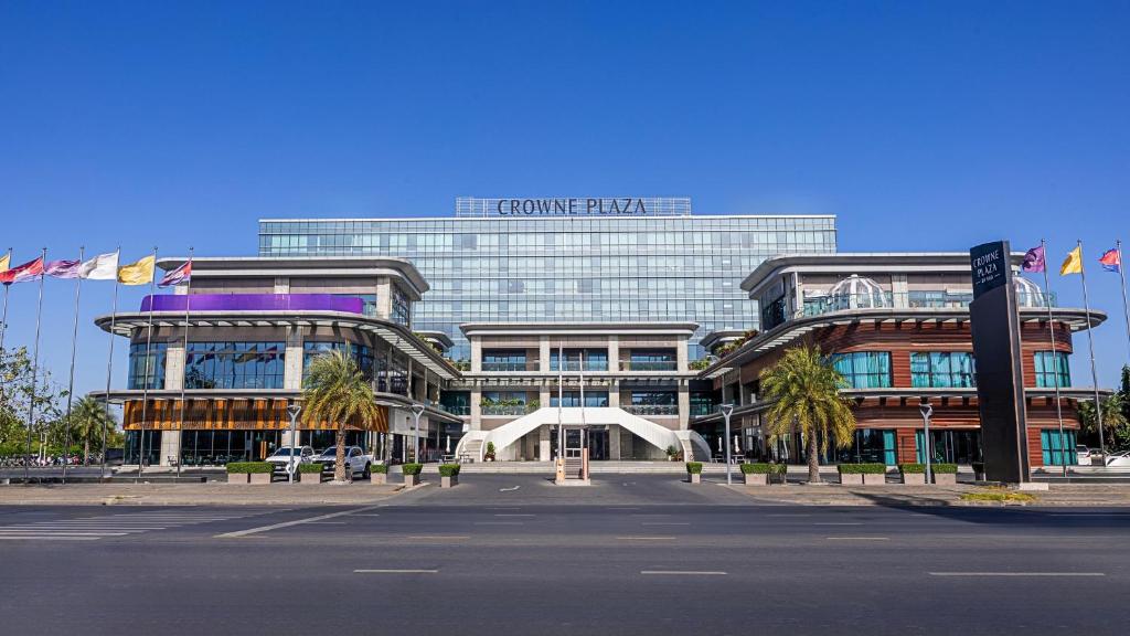 a large glass building with a sign on it at Crowne Plaza Phnom Penh by IHG 金边皇冠假日酒店 Former VM Hotel in Phnom Penh