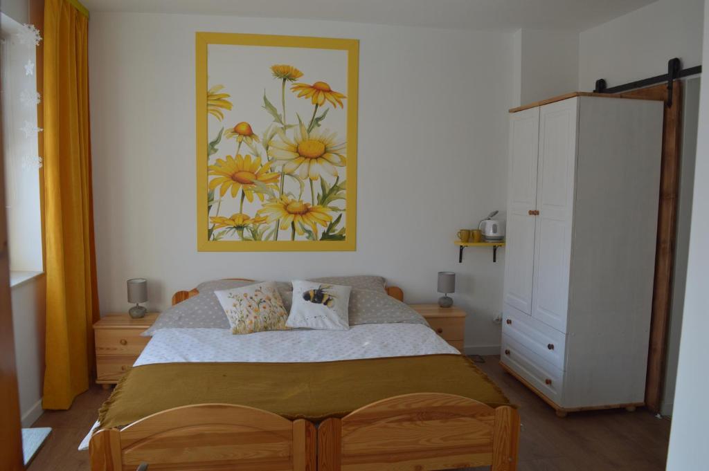 a bedroom with a bed and a painting on the wall at Mojone Izby in Maruszyna