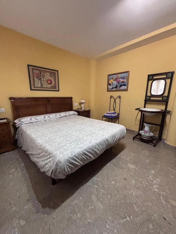 a bedroom with a large bed and yellow walls at Casa Rosa in Alcañiz