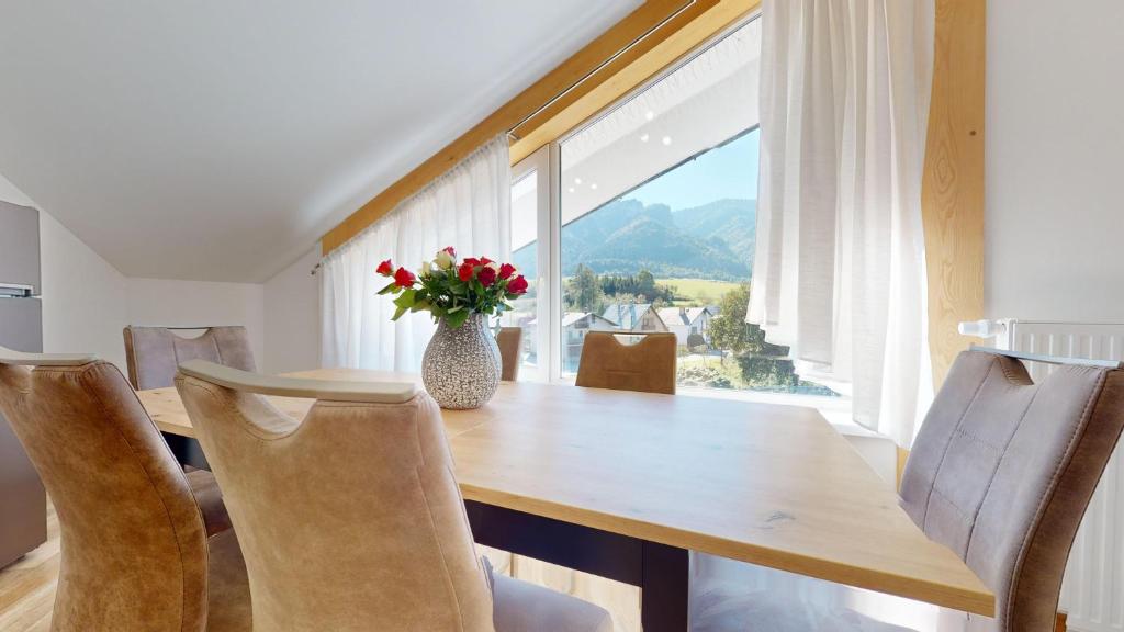 a dining room with a table and a vase with flowers at Apartmán Timea v Terchovej in Terchová