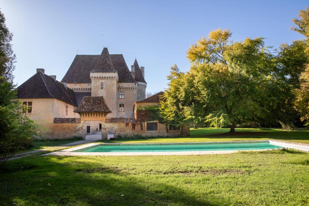 an old castle with a swimming pool in front of it at Château de Saint Maurice in La Peyrouse