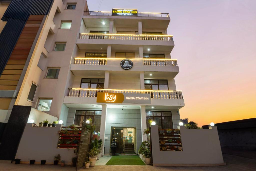 a building with a clock on the front of it at Itsy Hotels Saina Stay Near 32 Milestone in Gurgaon