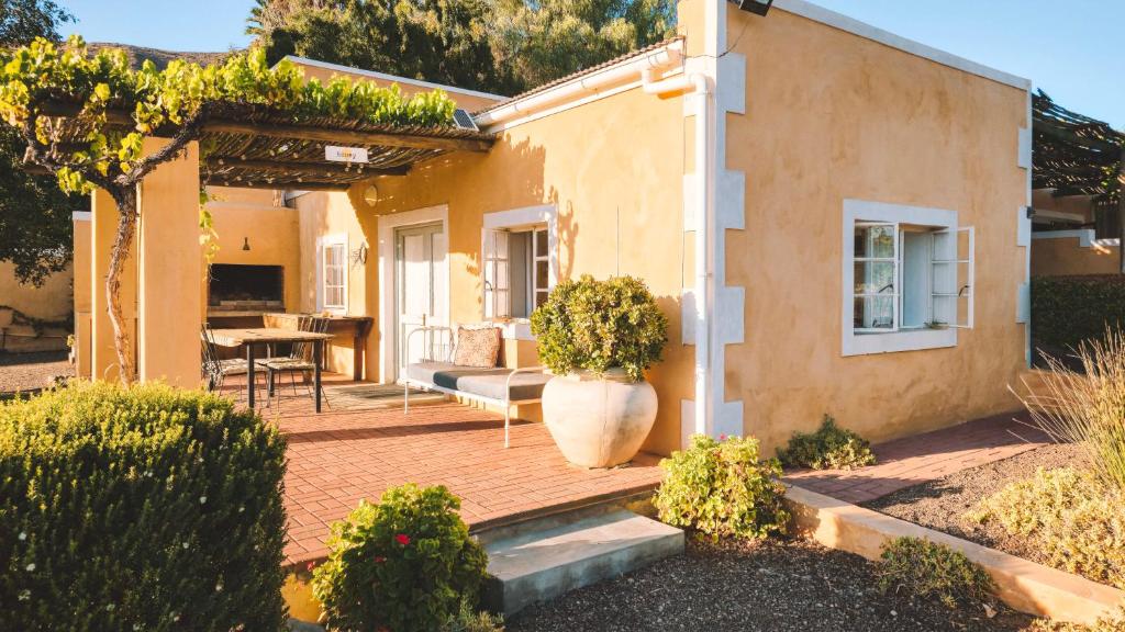a house with a patio with a couch and a table at Yellow House Prince Albert in Prince Albert