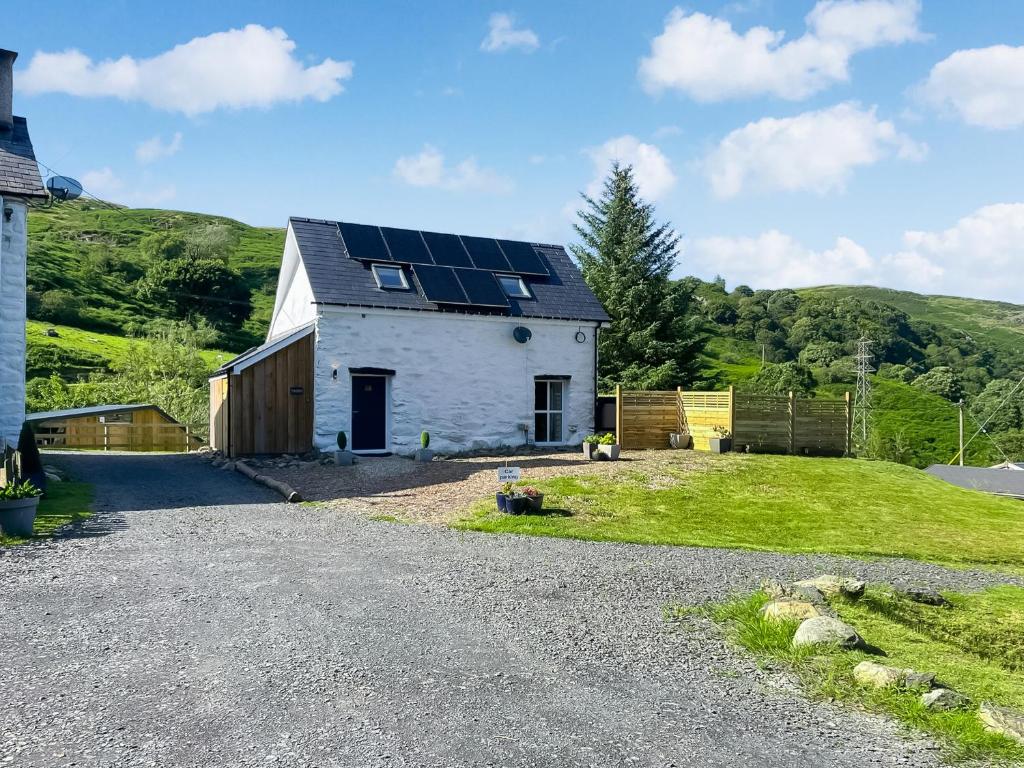 a white house with solar panels on the roof at The Barn in Llangwm