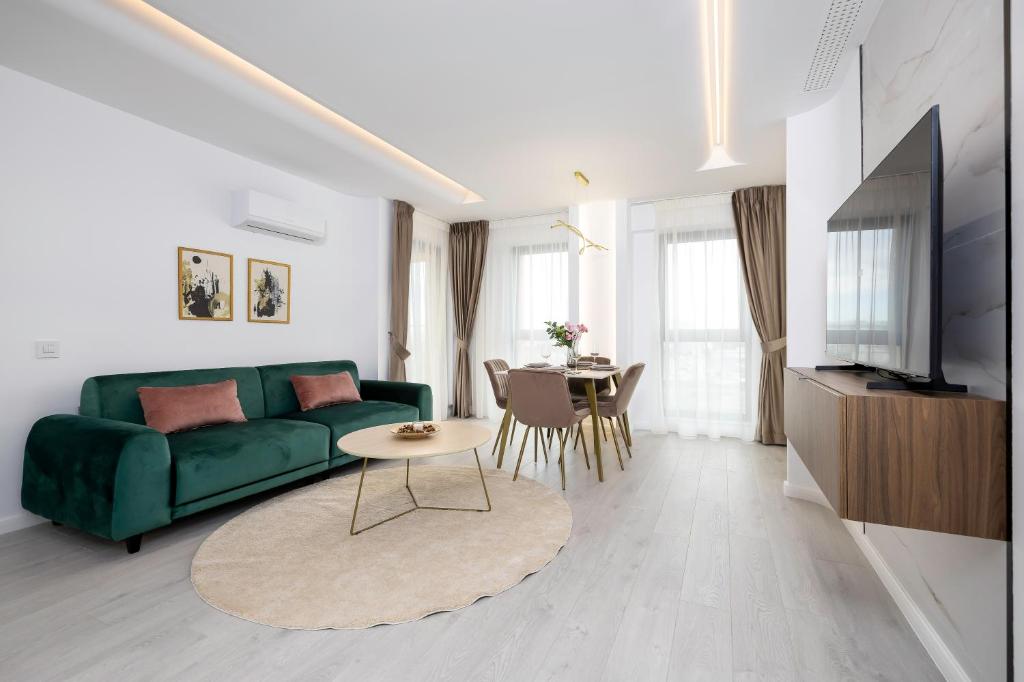 a living room with a green couch and a table at Lila Residence - by Solinis Homes in Bucharest