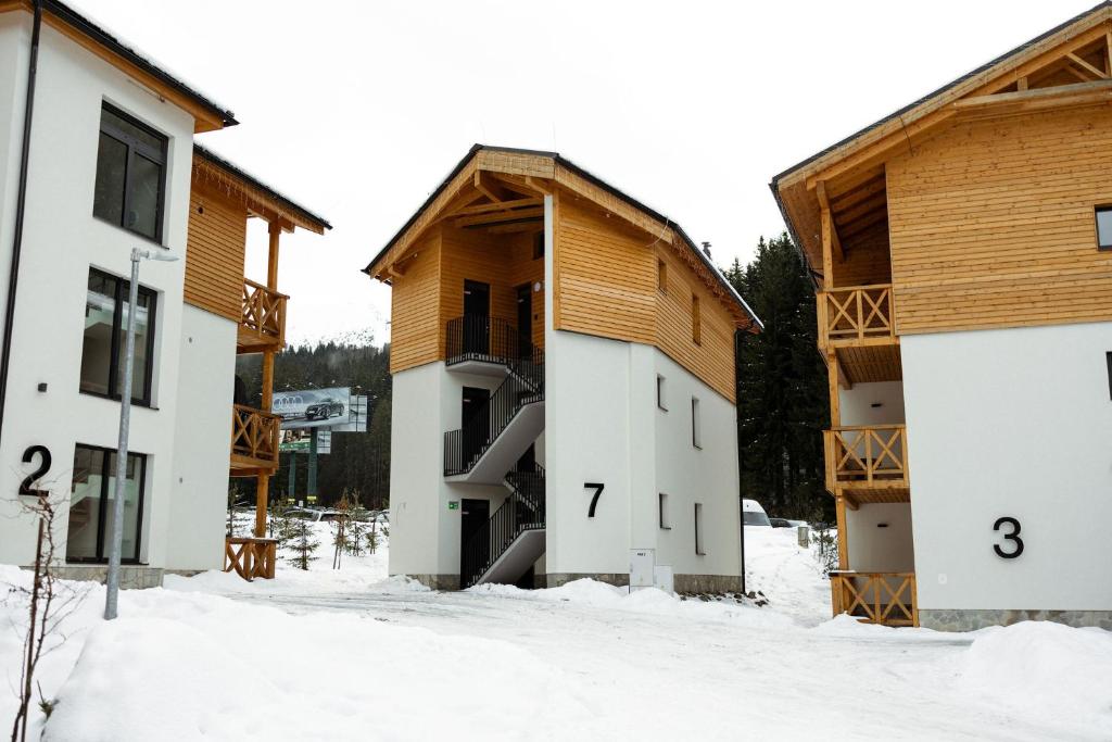 a group of buildings in the snow at Apartment Horalka - Jasná in Belá