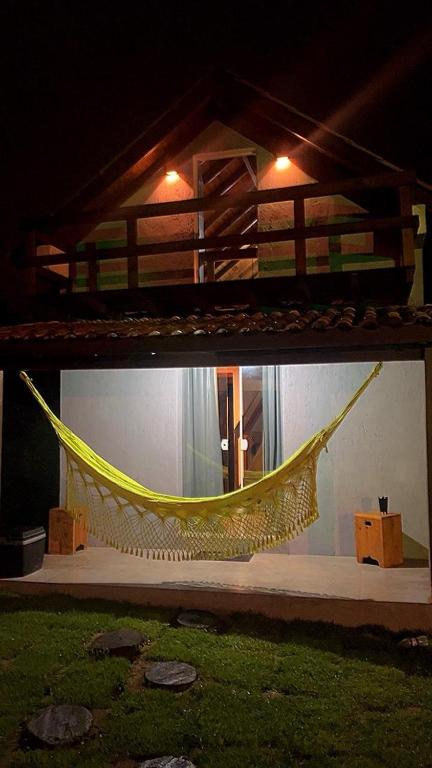 a hammock on the floor of a room at Casinha do Rosa in Imbituba