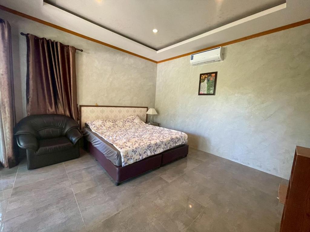 a bedroom with a bed and a chair in it at Koh Chang Hill-View Hideaway in Trat