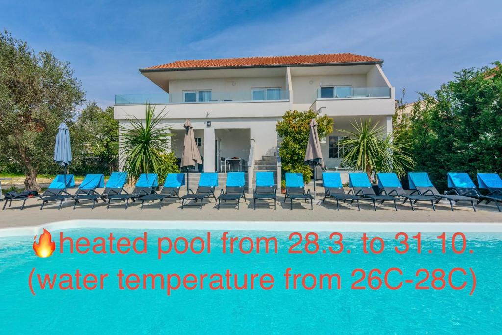 a house with a pool and chairs and a building at ROYAL CHOICE WITH POOL in Zadar