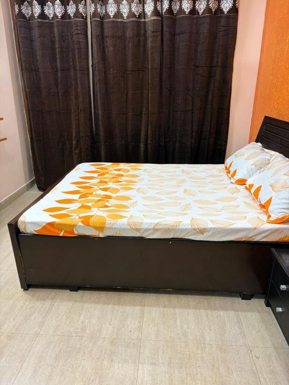 a bed in a bedroom with a black curtain at Good Vibes Retreat in Birbhaddar
