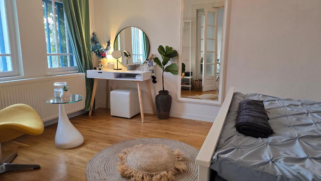a living room with a bed and a mirror at Apartament Centrul Vechi in Târgovişte