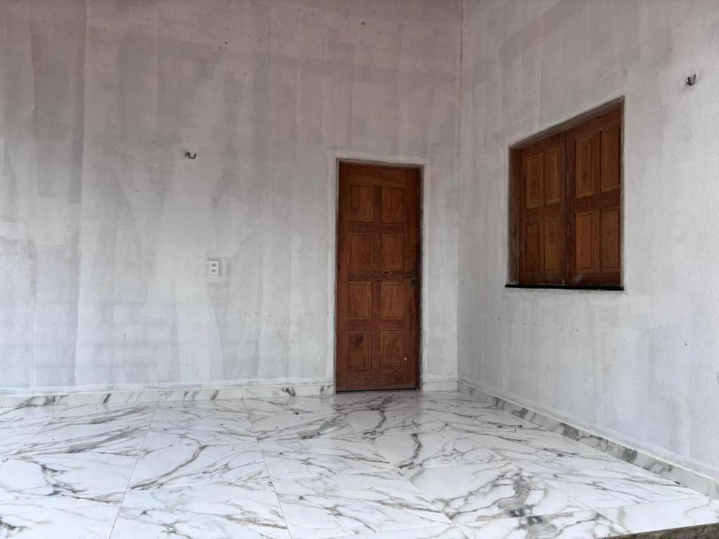 an empty room with a door and a marble floor at Casa na Floresta in Santarém
