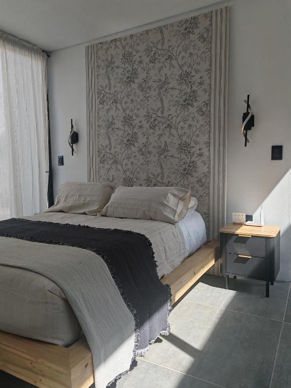 a bedroom with a large bed and a wall at Riviera Mendoza in Las Compuertas