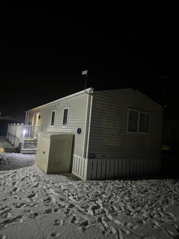 a house on the beach at night at Georgina Meadows in Skipsea