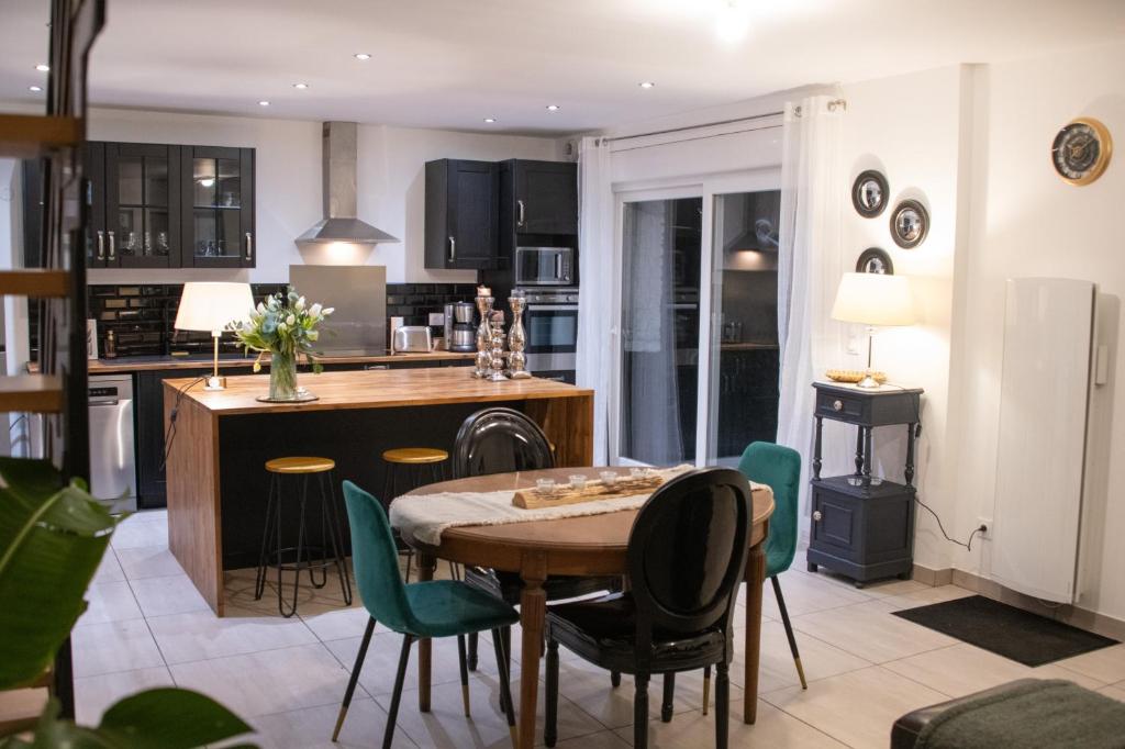 a kitchen and dining room with a table and chairs at Chez Léon in Hasnon