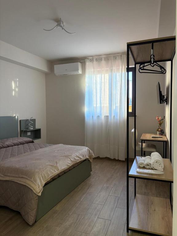 ein Schlafzimmer mit einem Bett und einem Tisch mit Handtüchern in der Unterkunft Capizzi Rooms in Bronte