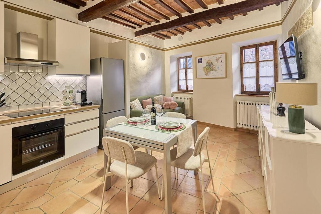 a kitchen and living room with a table and chairs at Vicolo Nobile in Montepulciano