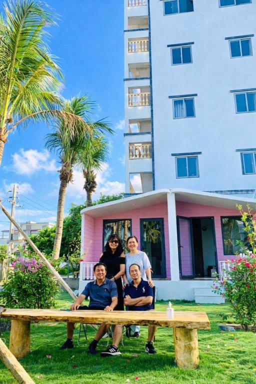 a group of people sitting at a picnic table in front of a building at An Phú Villa in Cu Lao Thu