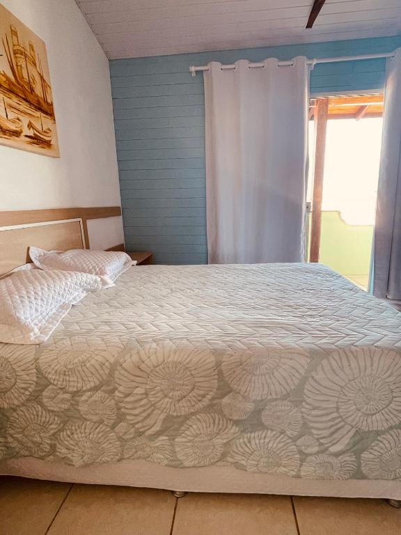 a bedroom with a bed and a window at Vista Mar Praia da Lagoinha - Residencial Pé na Areia in Bombinhas
