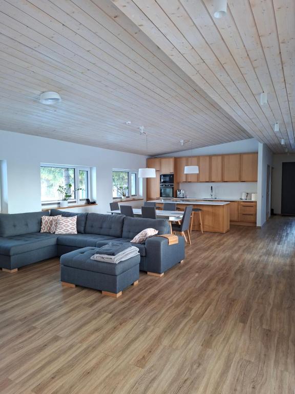 a living room with blue couches and a kitchen at Puhkemaja Pühajärvel in Otepää