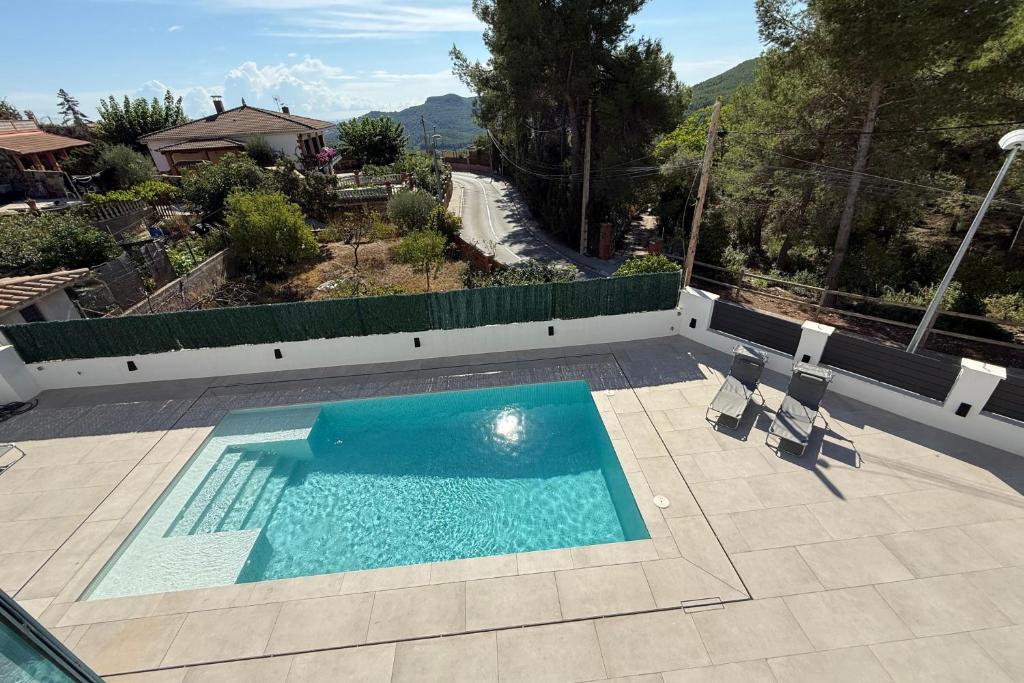 a swimming pool in a yard with two chairs at Casablanca-Private Family Mountain Home in El Amunt