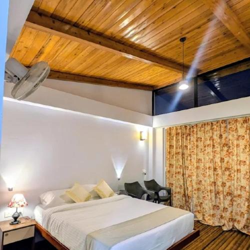 a bedroom with a white bed and a wooden ceiling at Stay At Cottages in Pynursla