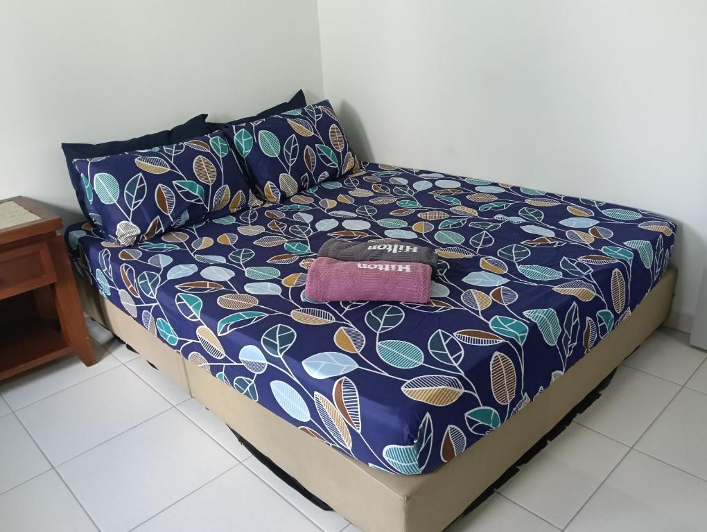 a bed with a purse sitting on top of it at Homestay Gapam Kasih in Bemban