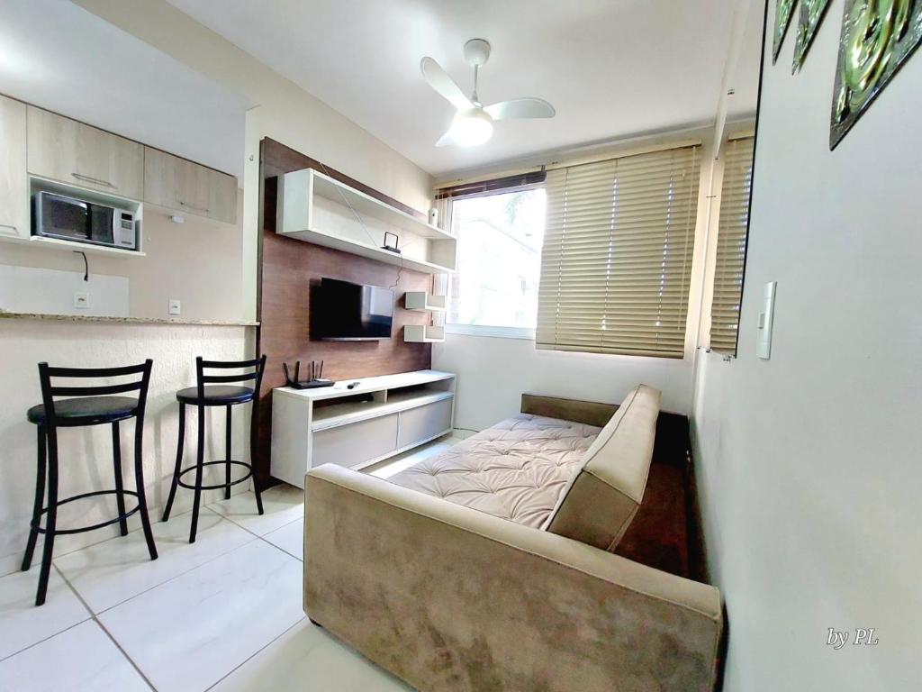 a living room with a couch and a kitchen at Graciosa Reserva Ipanema in Porto Alegre