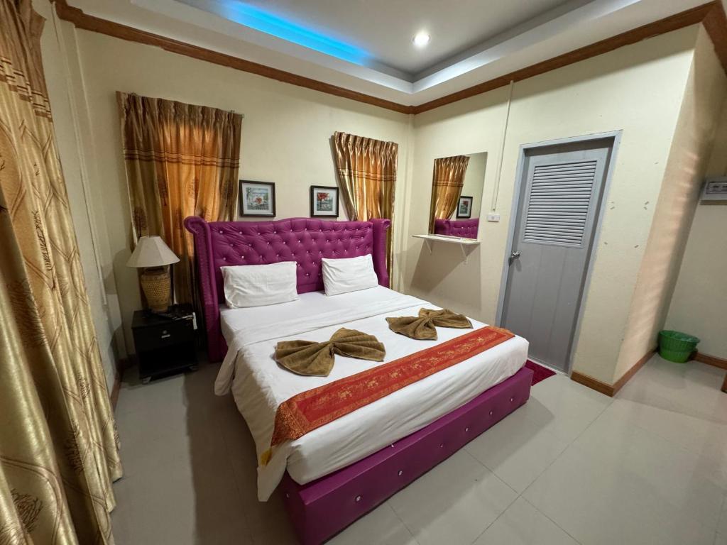 a bedroom with a large bed with a purple headboard at Ruen Thong Resort in Phang-nga