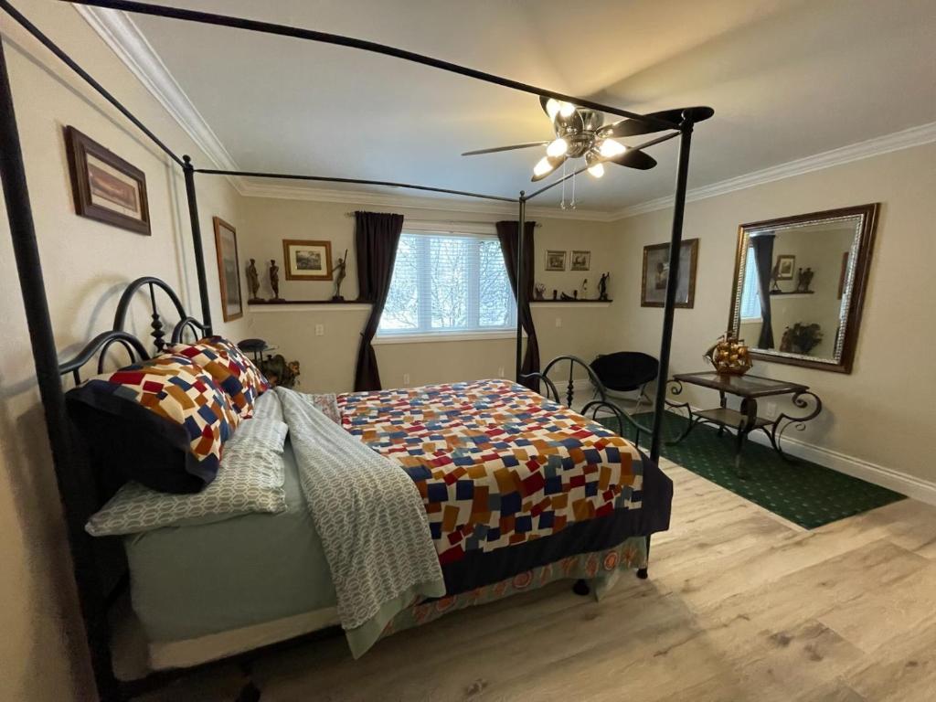 ein Schlafzimmer mit Bett und Deckenventilator in der Unterkunft Khan’s Resort in Cobourg