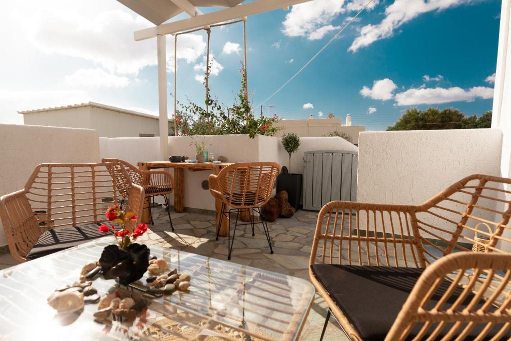 a patio with a table and chairs on a balcony at DM Seaside House in Perissa