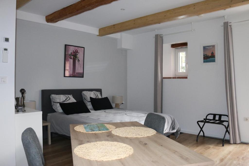 a room with a bed and a table and a bed at L'Autan sage in Montgeard